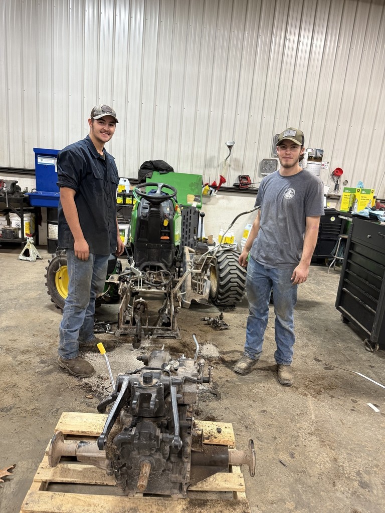 Two students with a tractor parts