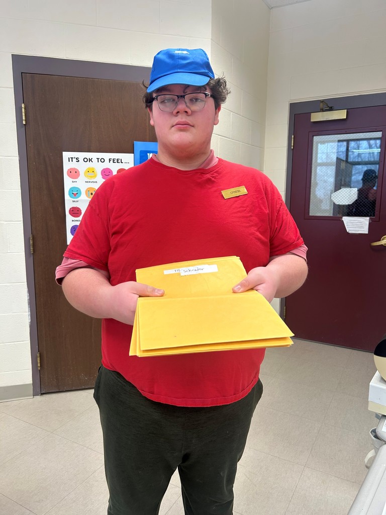 Student working in school cafe holding envelopes with orders