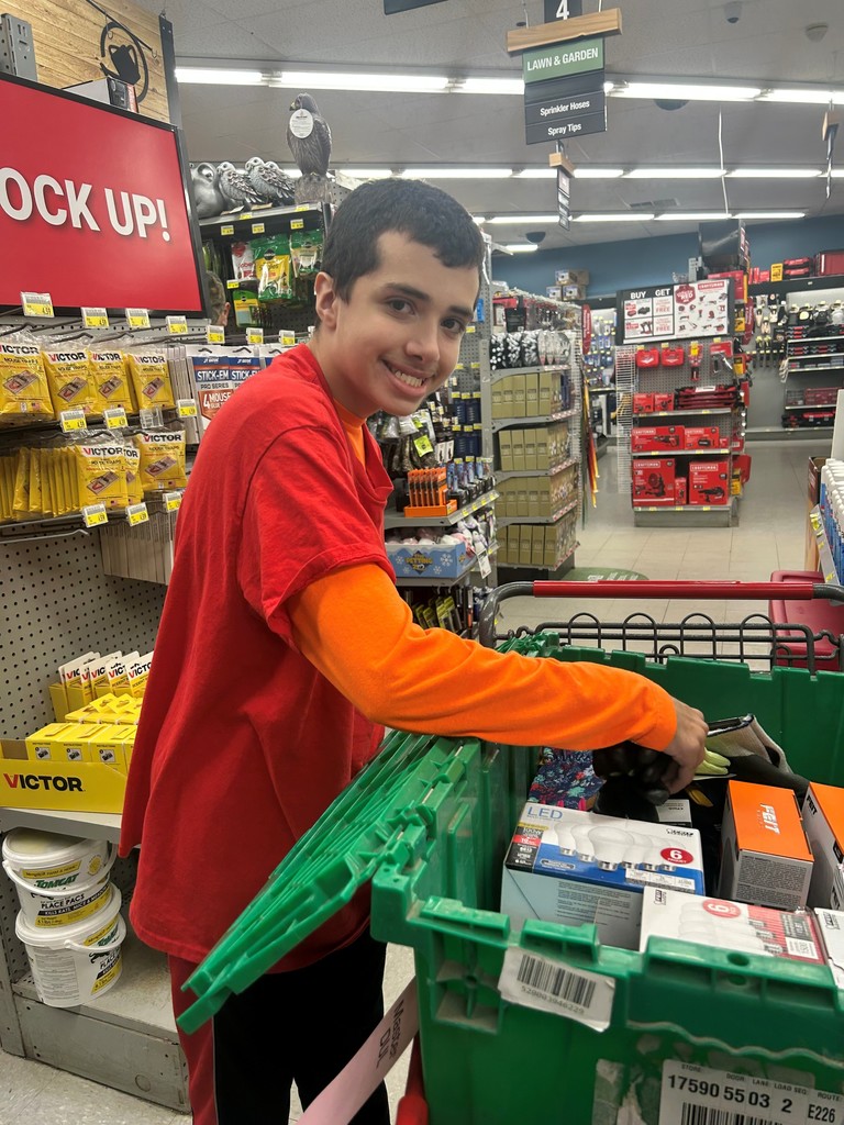 Student working in a store with a cart of items