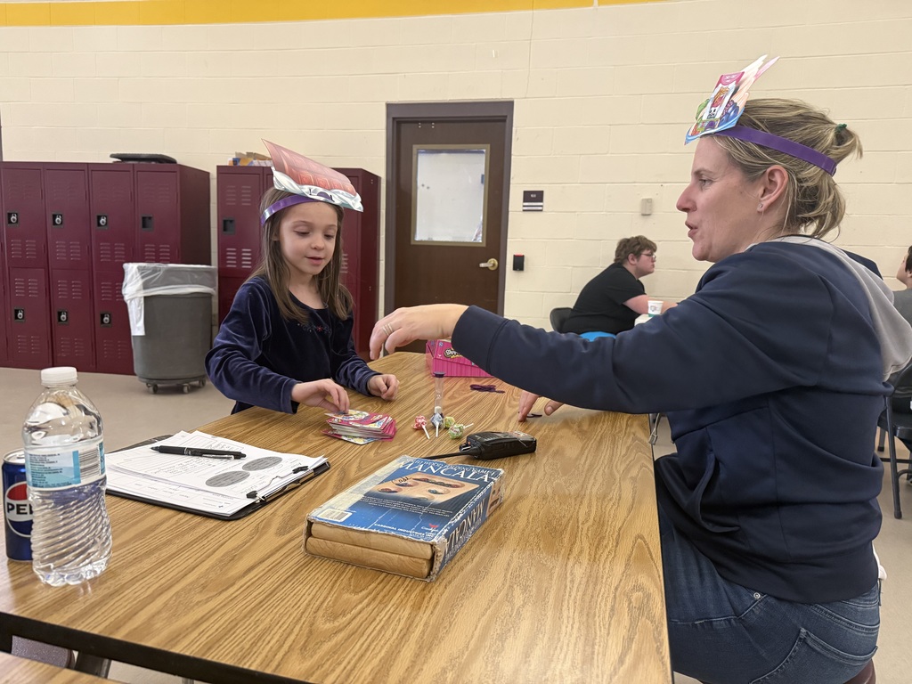 Student and staff member playing a game at a table