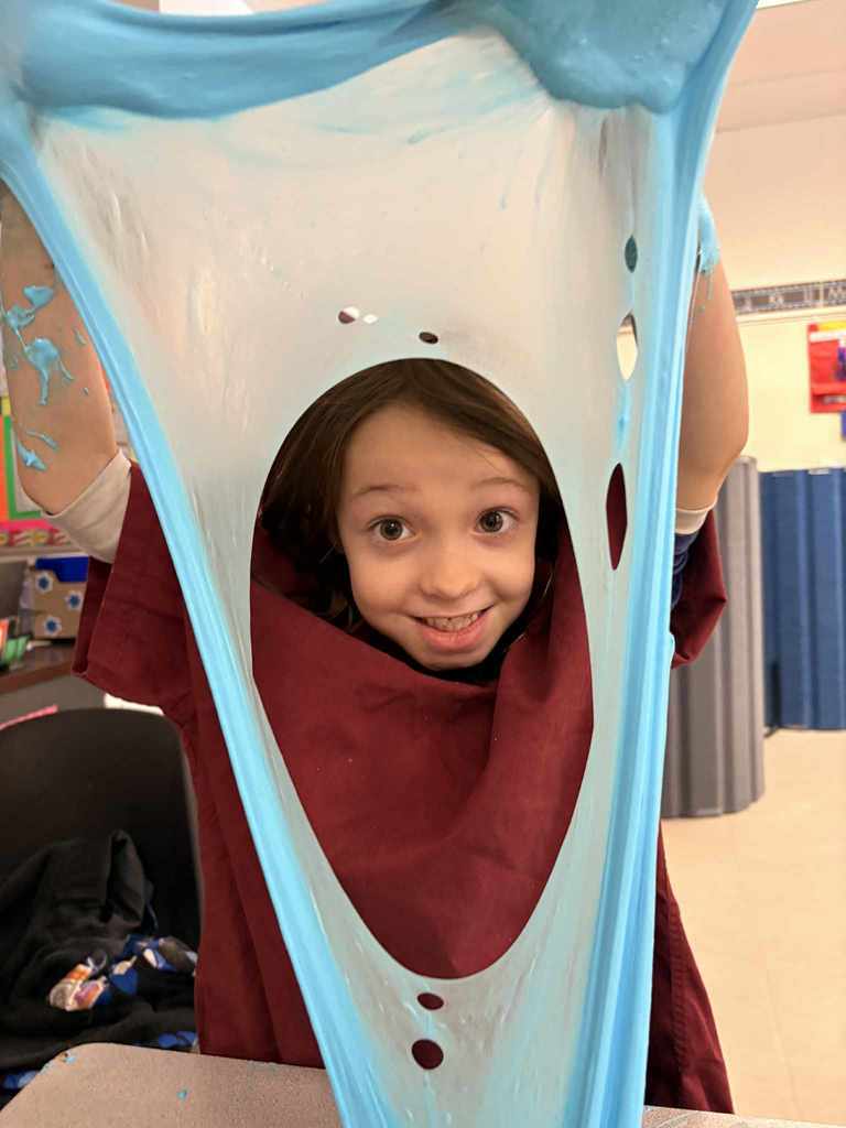 Student with fluffy slime stretched to  make a large hole