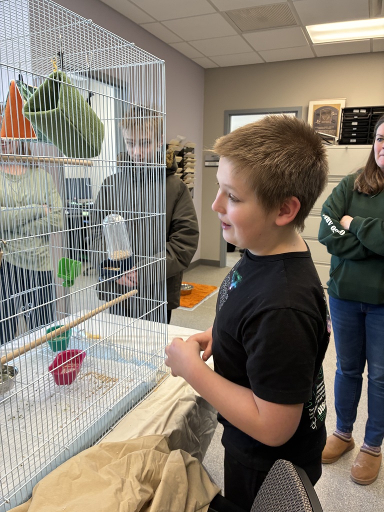 Students and staff member looking in an animal cage