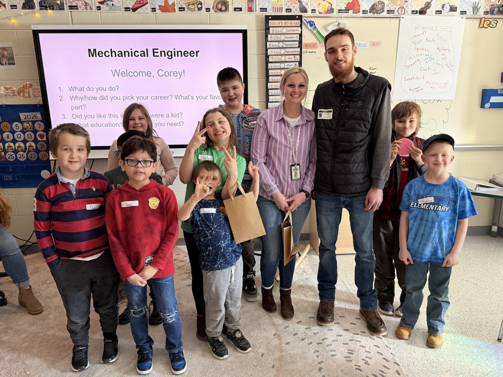 Group of elementary students and teacher with guest speaker, Corey, Mechanical Engineer.