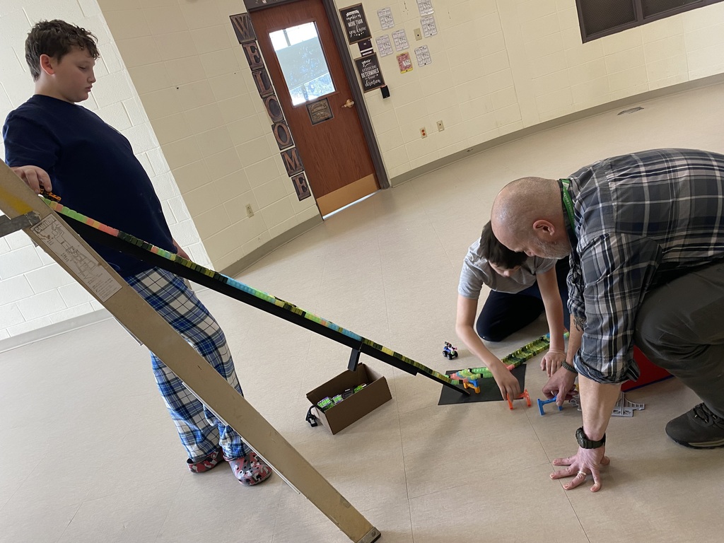 A student and teacher on the floor working with building toys