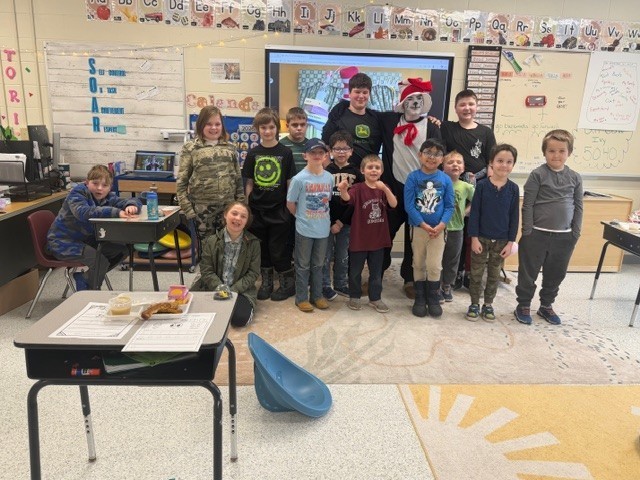 A group of elementary students with high school student dressed as The Cat in the Hat