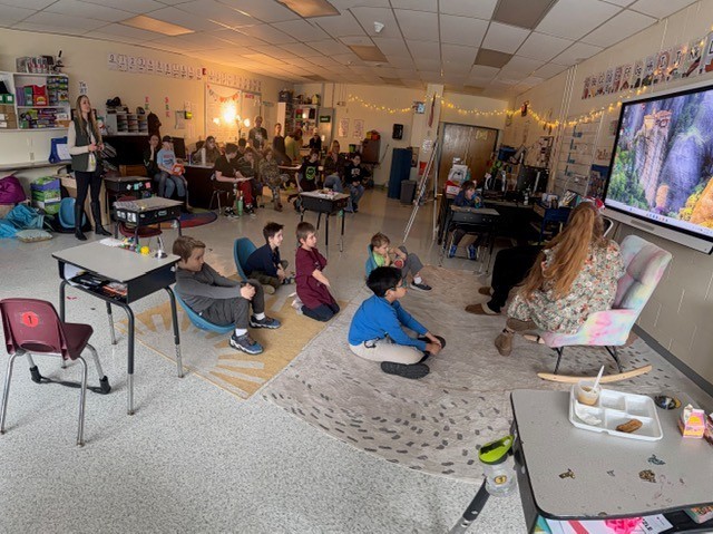 Students sitting and listening to a teacher reading The Cat in the Hat