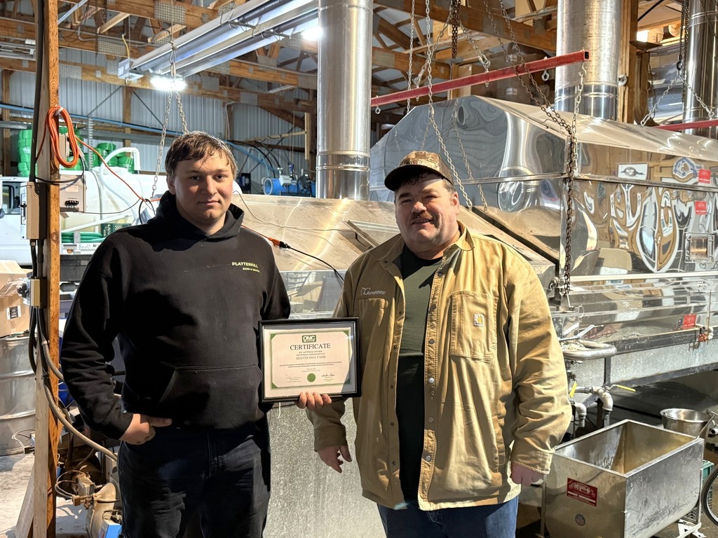 Student and employee at Shaver Hill Farms holding a certificate.