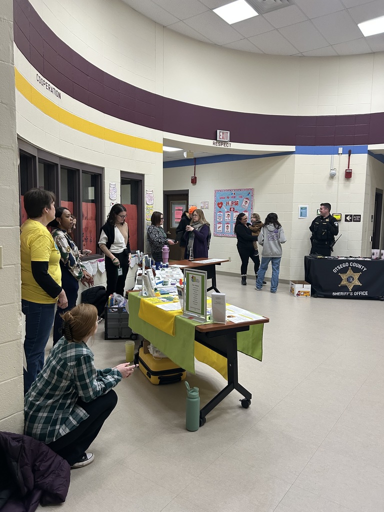 Students and guests in the hallway of OAOC with tables of local businesses