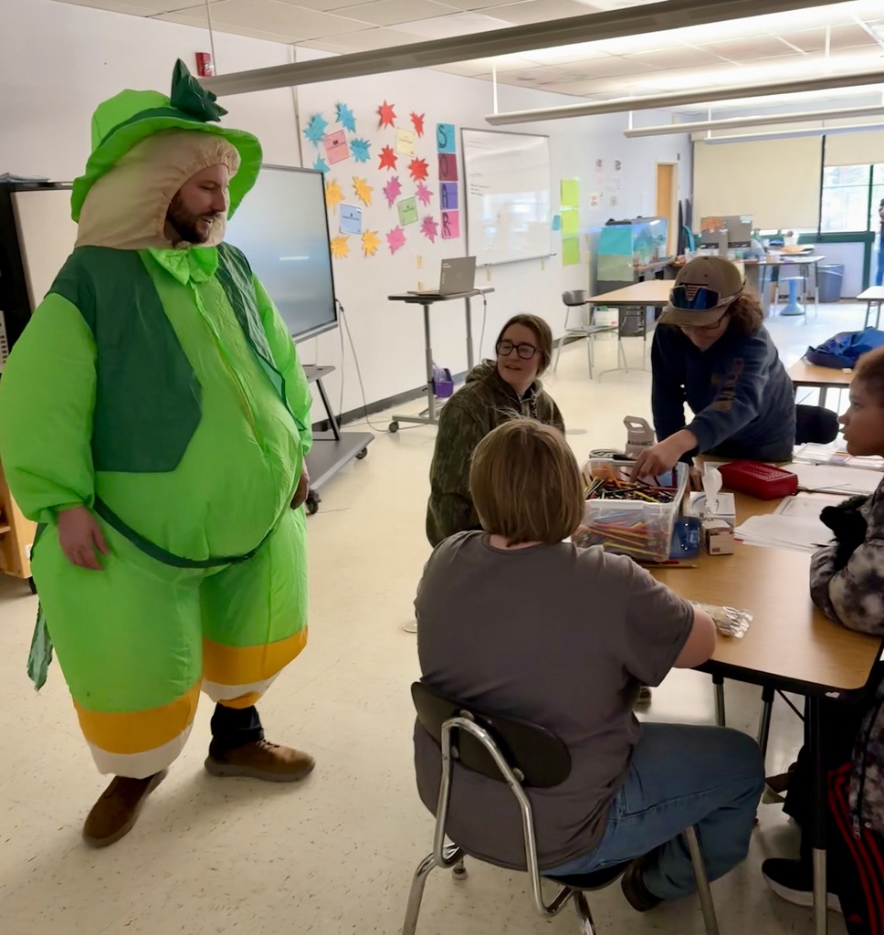 Principal in a leprechaun suit visiting students in classroom