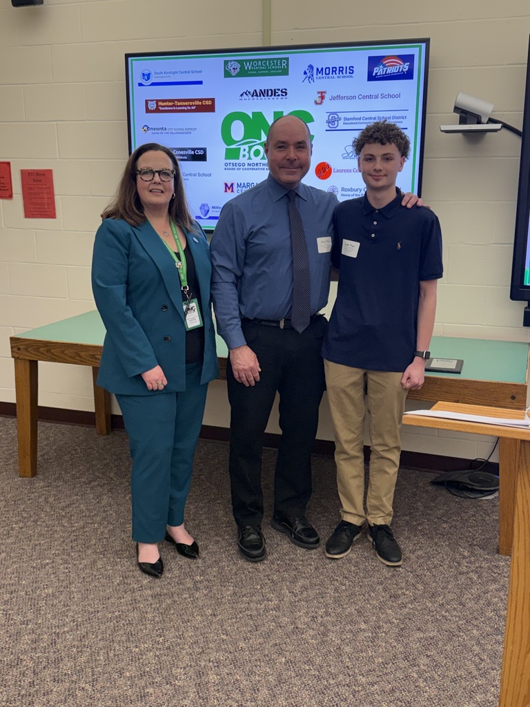 ONC District Superintendent, New Visions Engineering Instructor, and New Visions Engineering student posing in front of a screen that has the ONC BOCES logo with the 19 component districts logos.