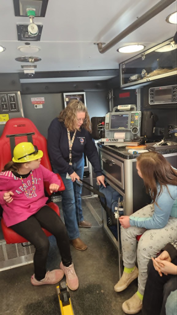 Two students and an EMT inside the EMT truck