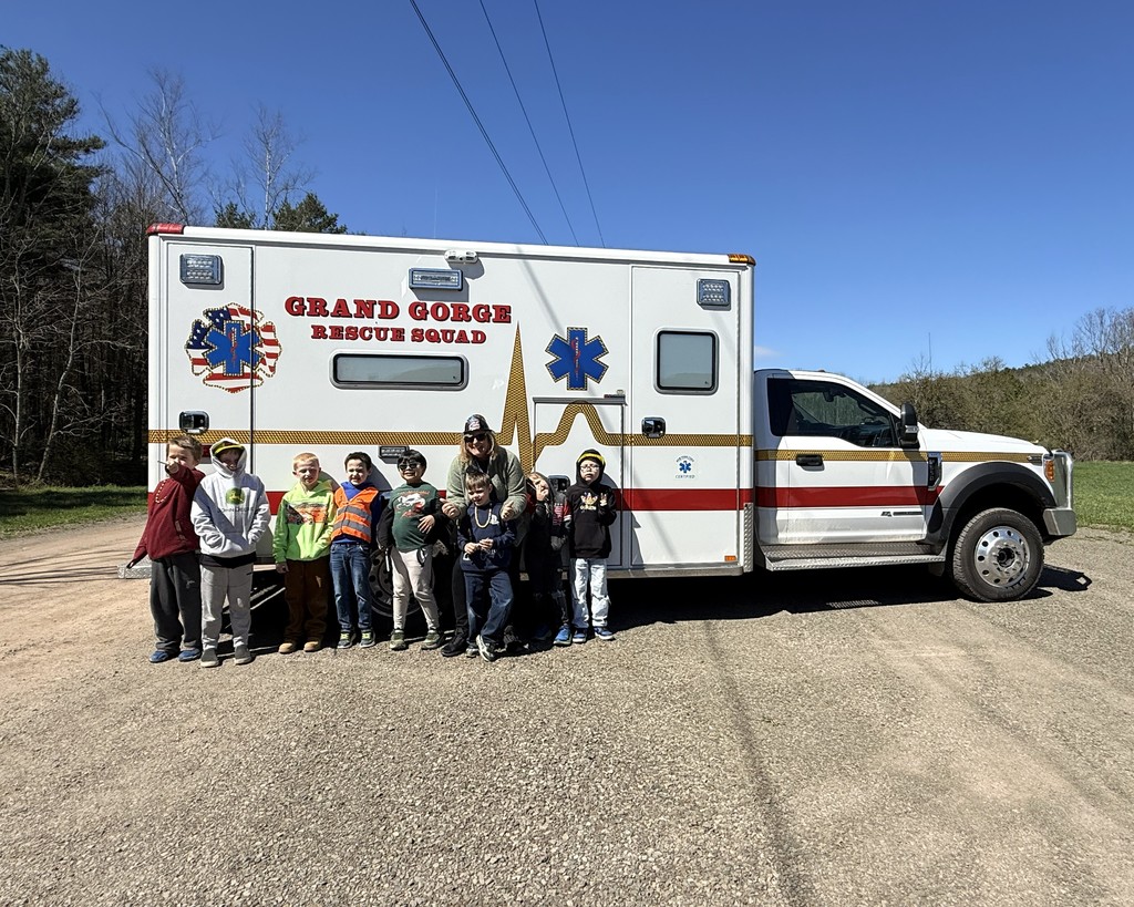 8 elementary students and one adult standing in front of the white Grand Gorge Rescue Squad truck