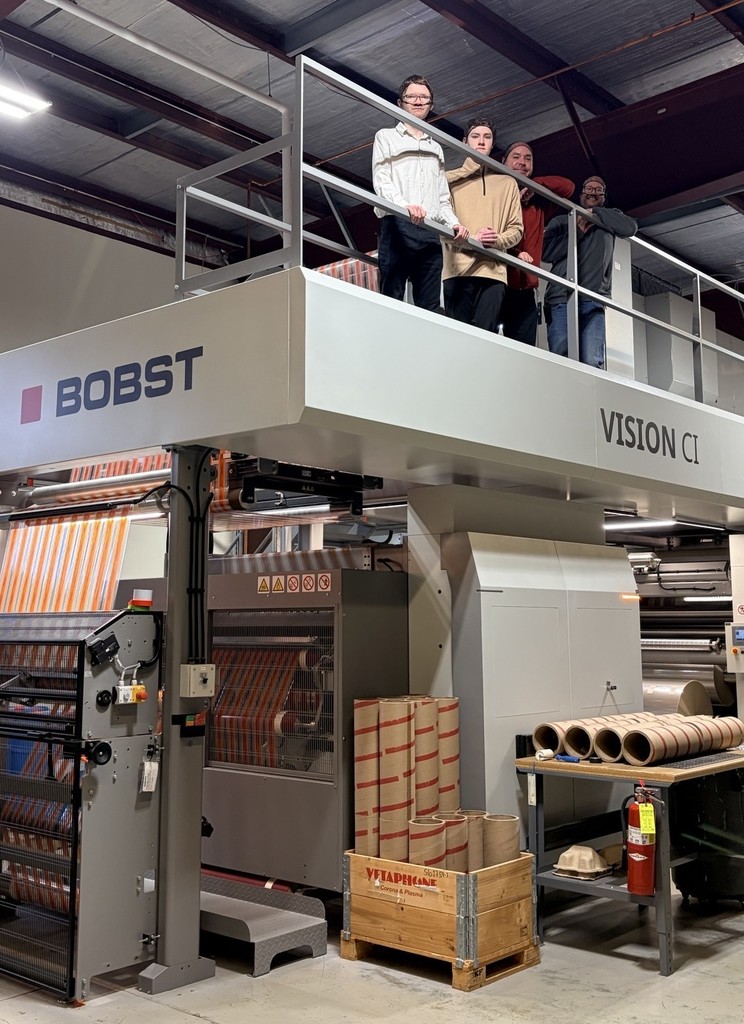 3 students and a staff member standing on a machine