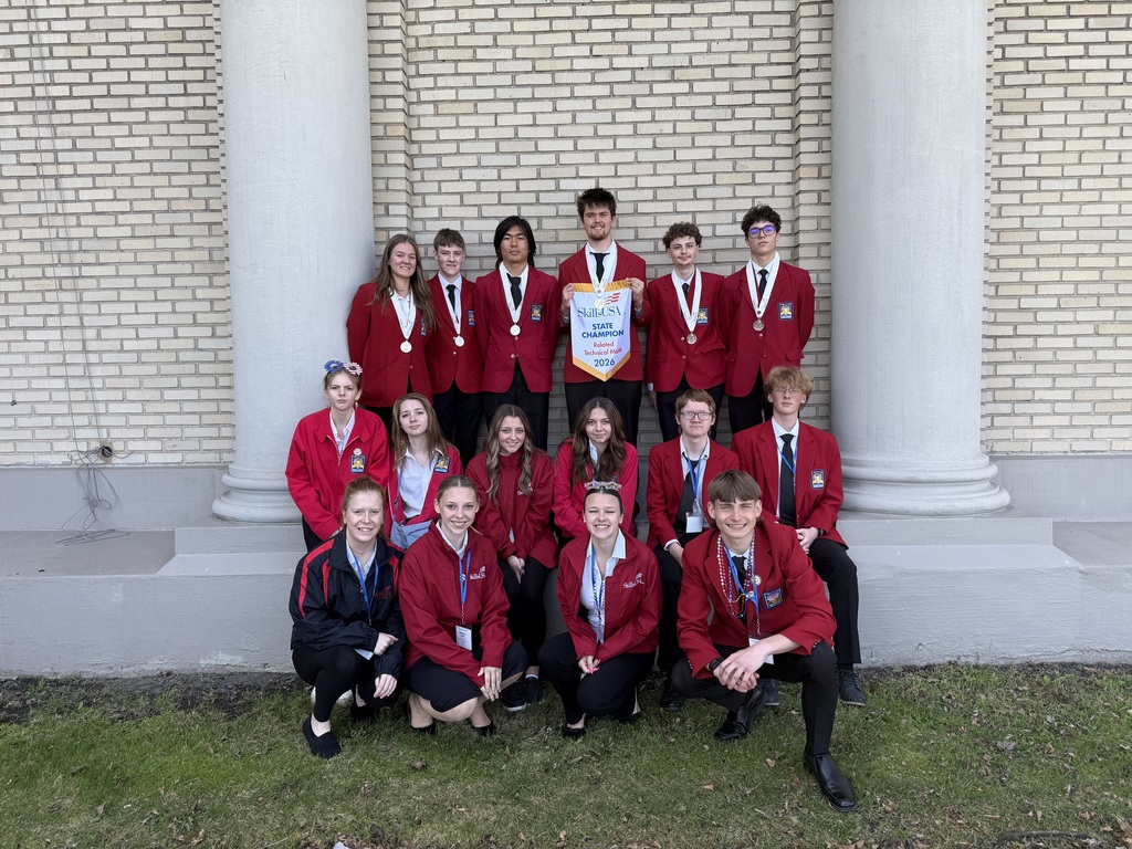16 students wearing red tops and black bottoms. Six have medals. One holding the banner that says SkillsUSA State Champion related technical math 2026