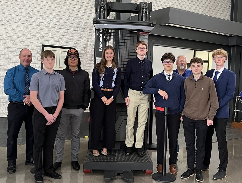 7 students, instructor, and Raymond employee posing for a picture