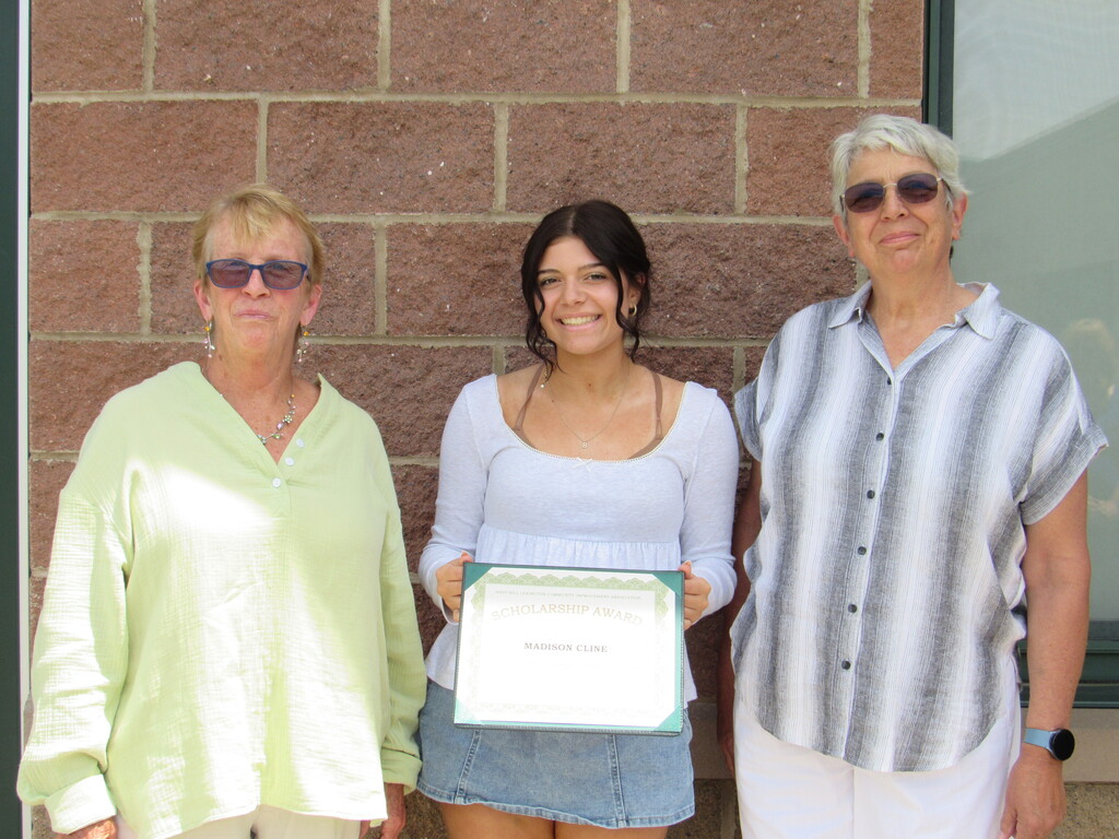 Student holding her certificate and two members of the west kill community center.