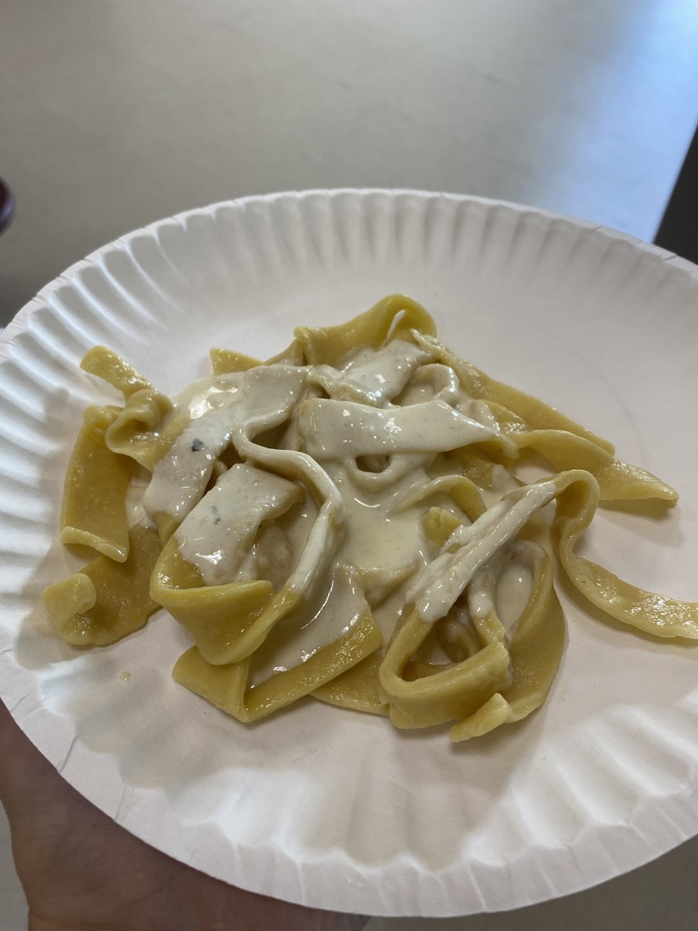 Cooked noodles with sauce on a paper plate