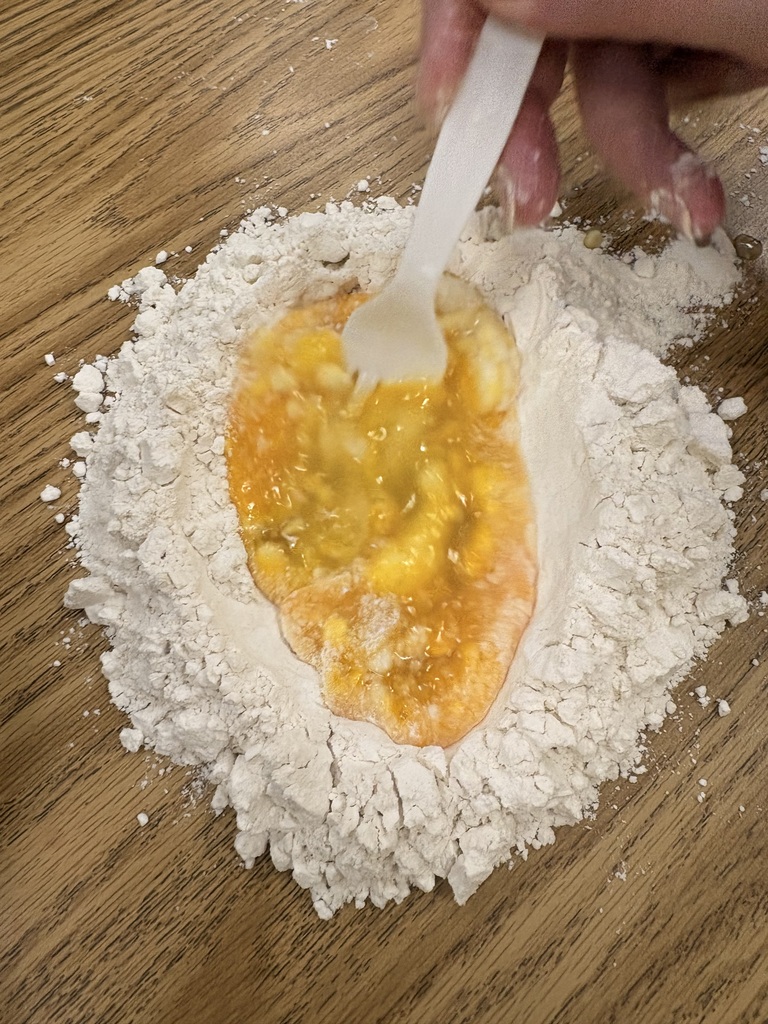Flour on a table with a well of egg