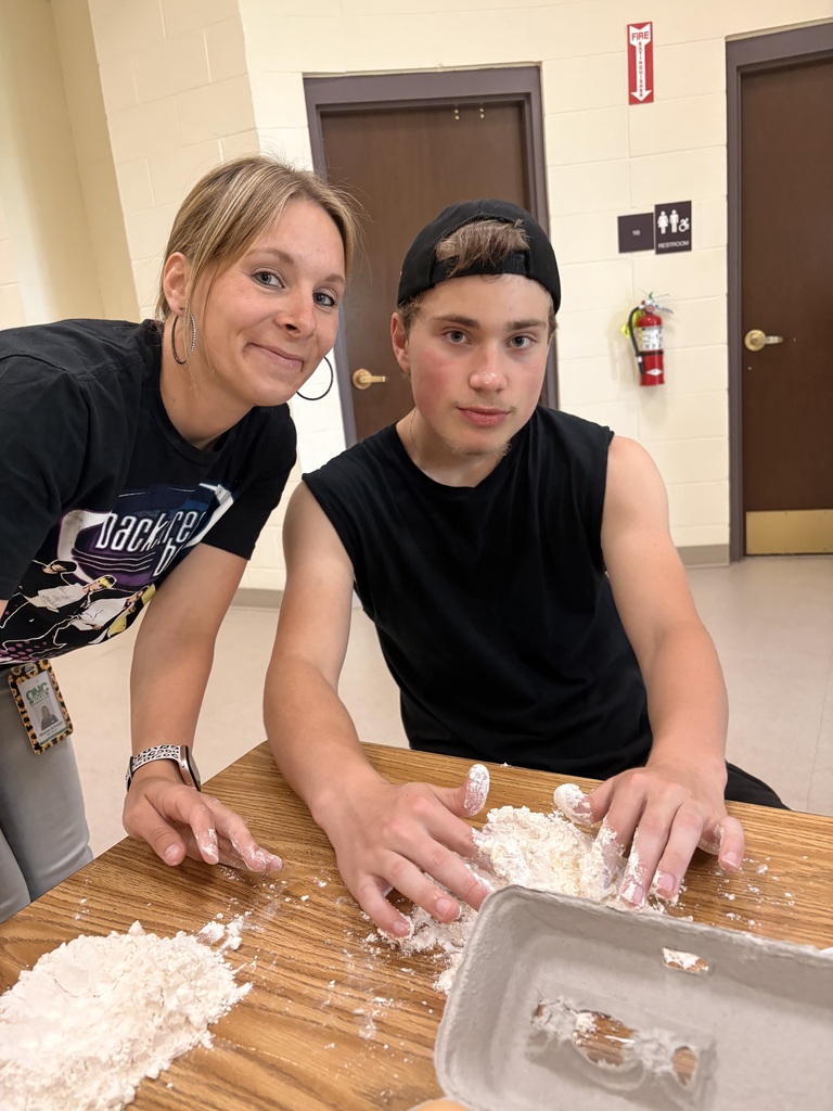 Student and staff member working with pasta dough