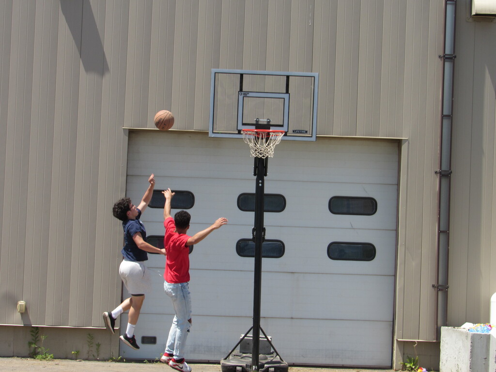 Two students playing basketball outside