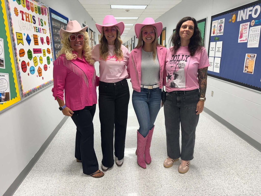 Four staff members dressed in pink posing for a picture