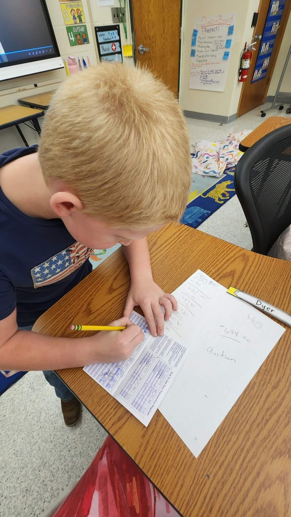 A student a table writing in a check register
