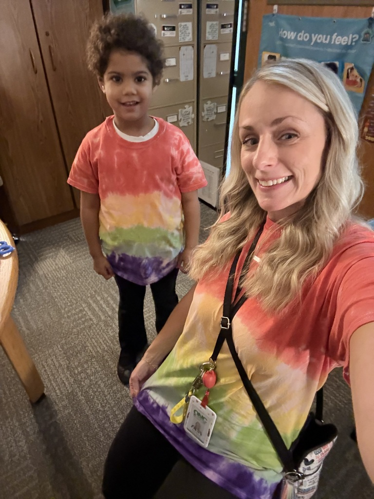 A student and a staff member taking a selfie in their tie dyed shirts