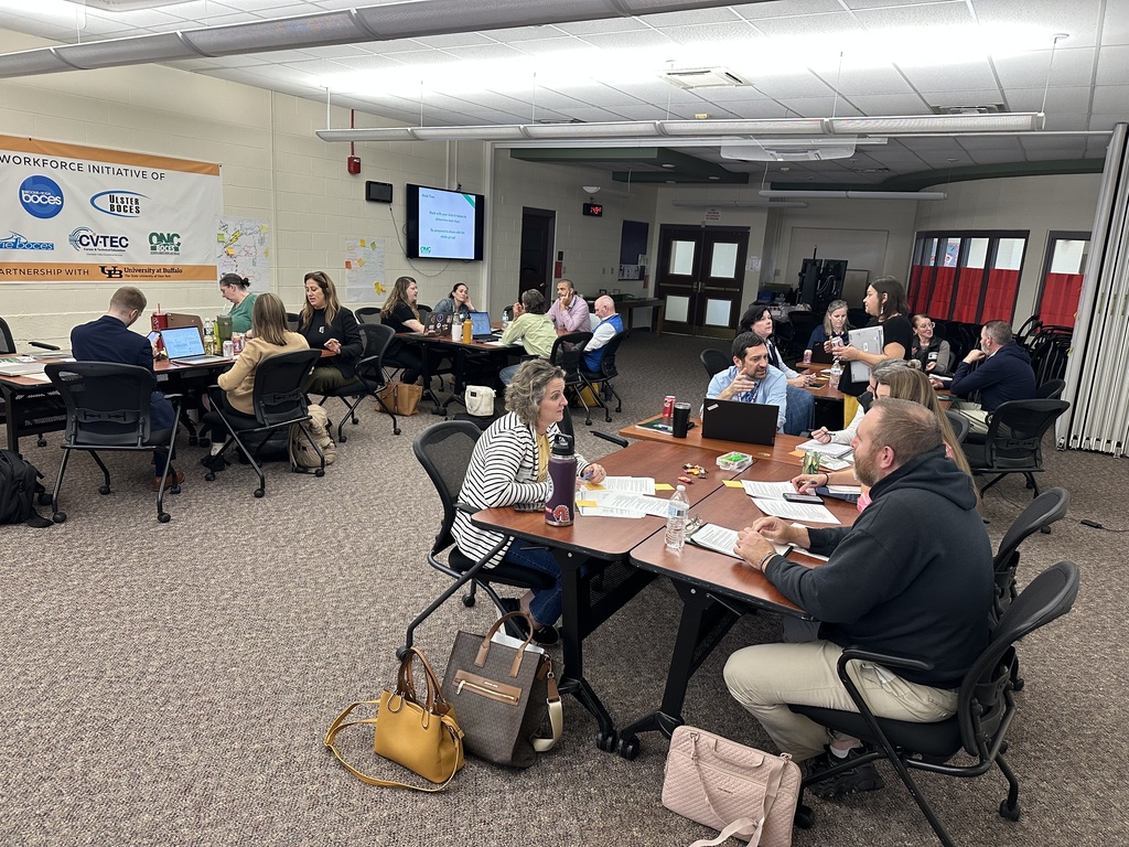 Picture of a room with people working at small groups of tables