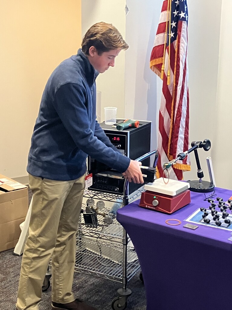Student standing by a table with equipment