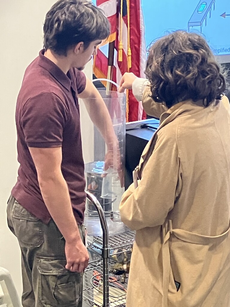 Two students working with a piece of equipment