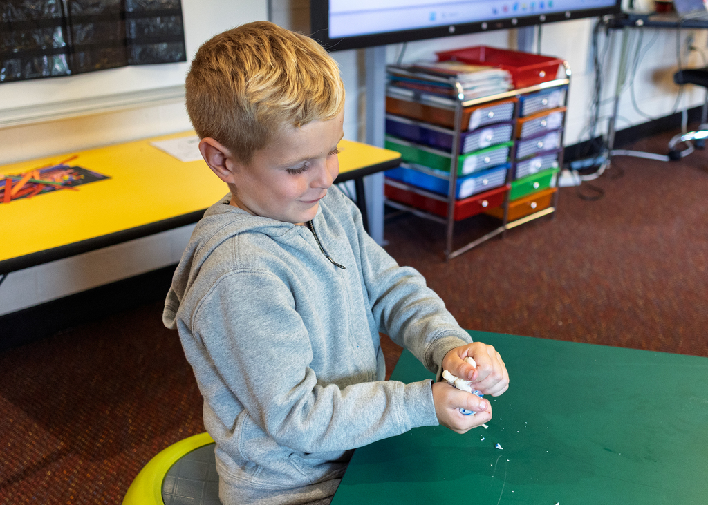 Student squeezing the playdough