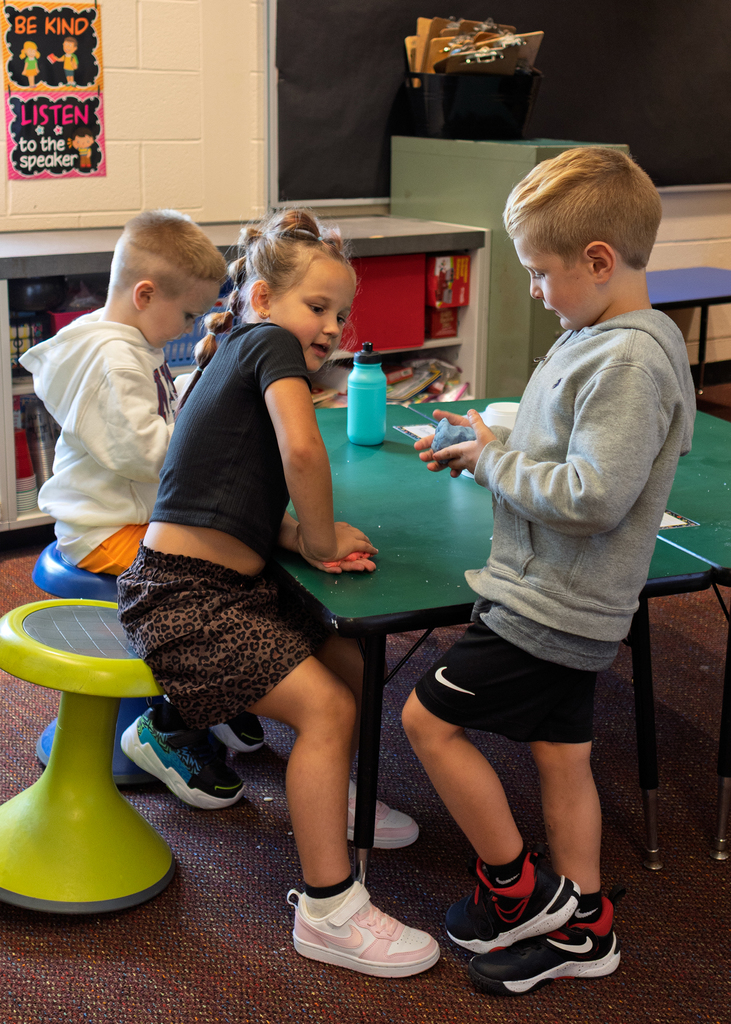 Kindergarten students squeezing the play dough!