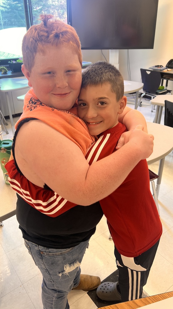 6th grade cooking class makes fluffy pancakes, 2 students are hugging