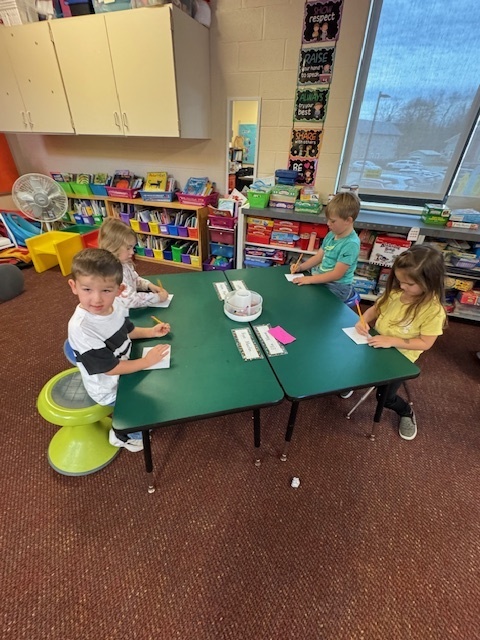 Kindergarten students write out CVC words and play CVC basketball