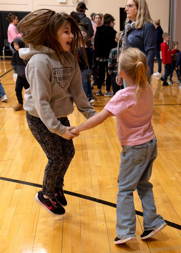 Students join hands and dance