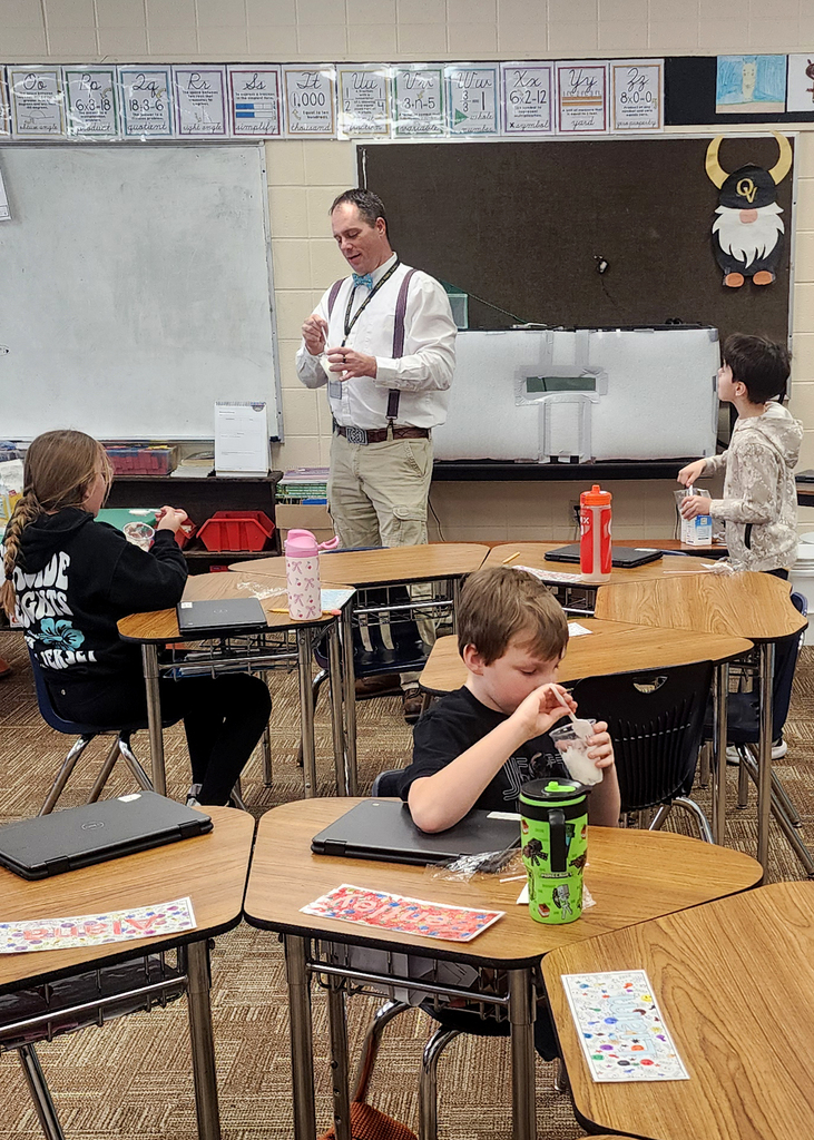 Mr. Gross standing in front of the class while they are all eating snow ice cream