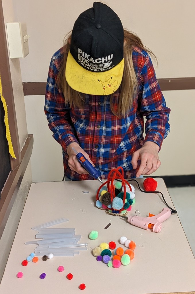 Close-up of a student holding a handmade craft created during mentoring activities.