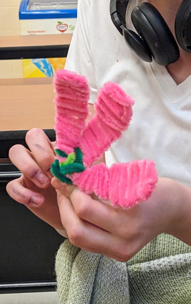 Close-up of a student holding a handmade craft created during mentoring activities.