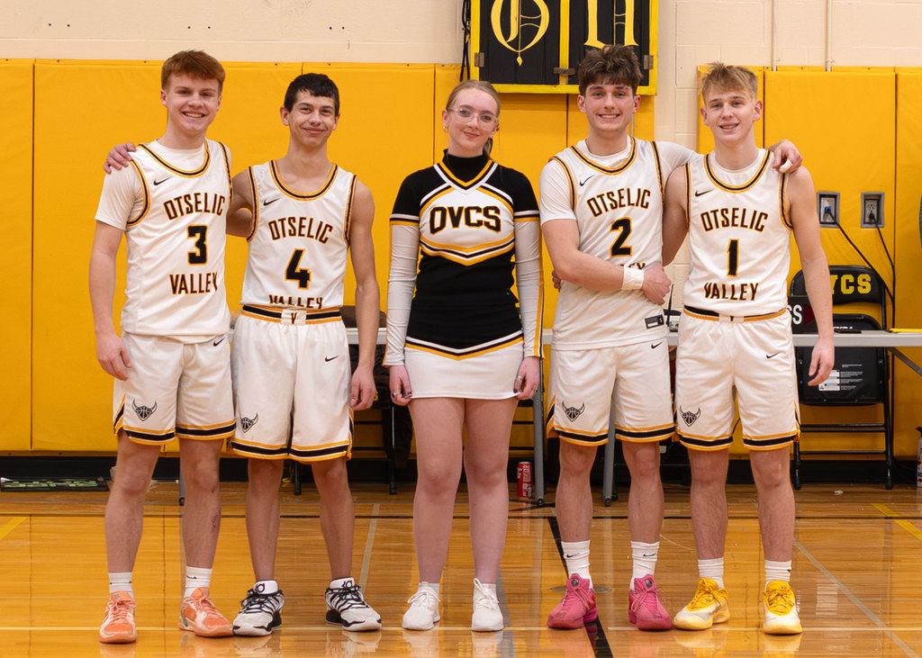 The five seniors standing in the gym