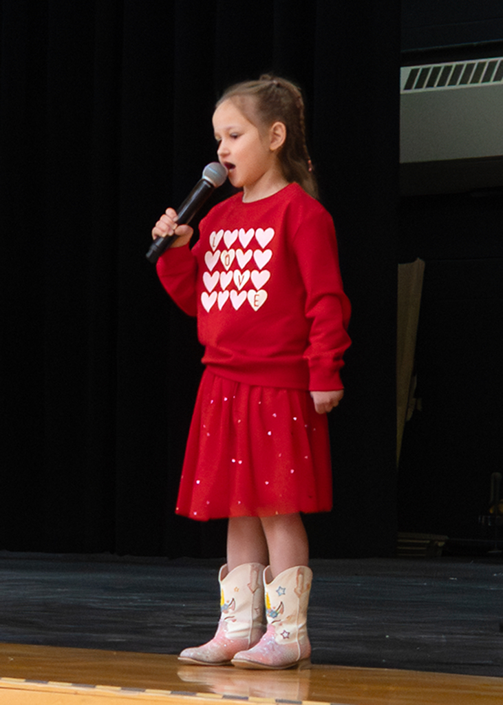 A student singing on stage