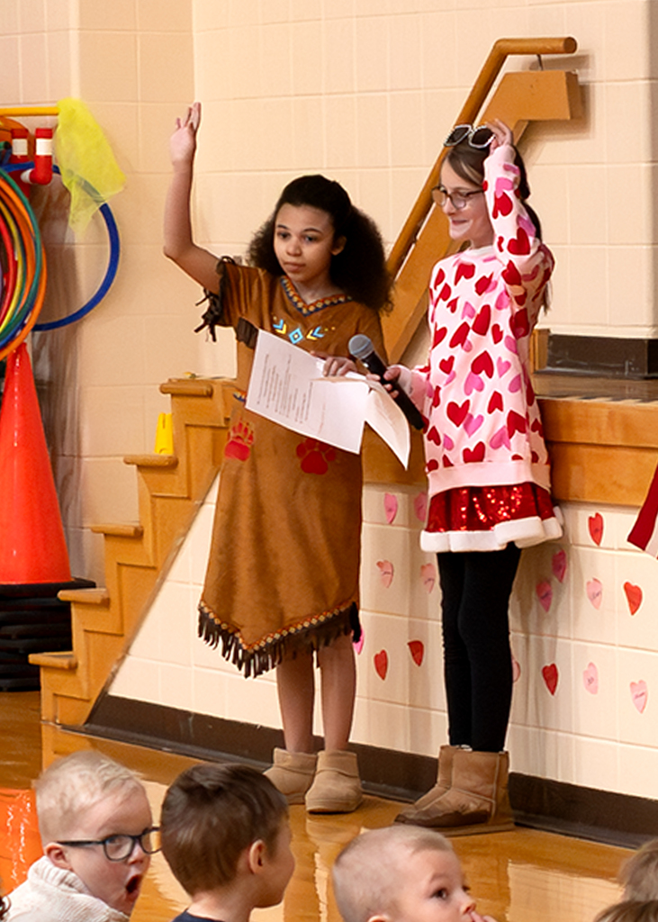 Students standing with their arms raised