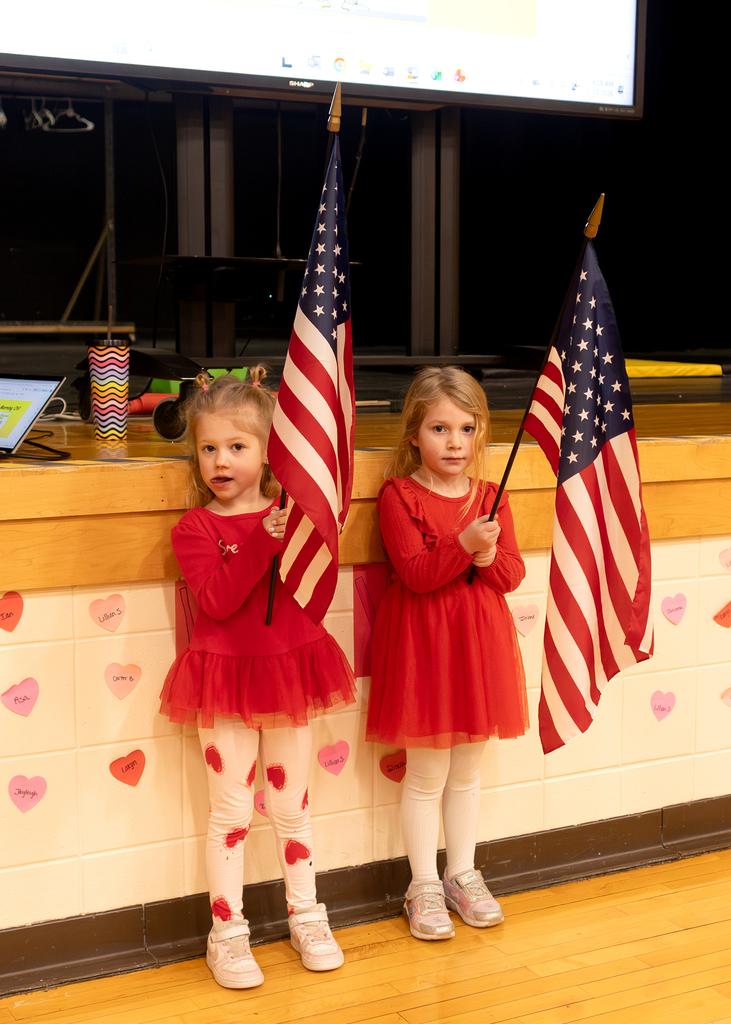 Student flag bearers standing in front of the stage