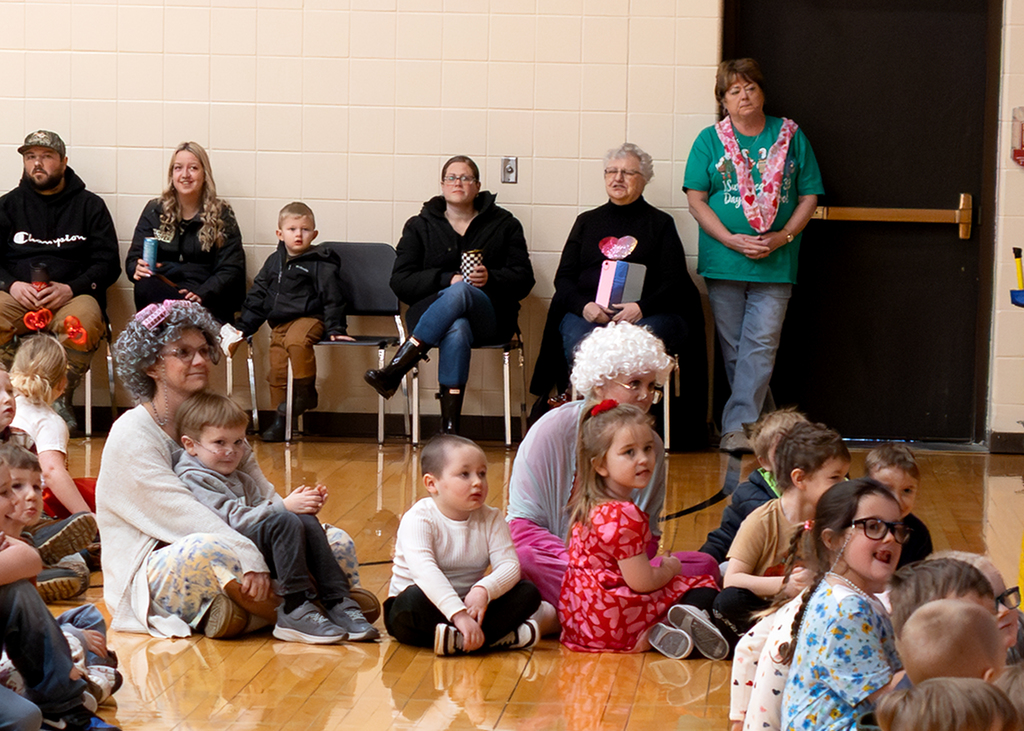 Teachers sitting with students on the floor