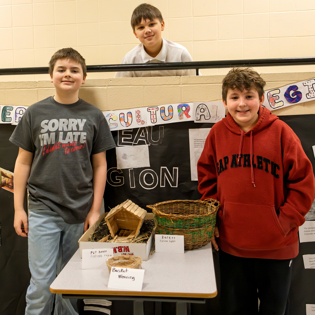 Three students pose with their poster and projects