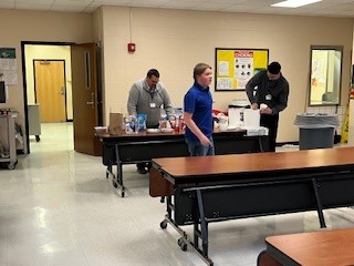 Staff setting up ice cream cups and supplies for students during an incentive event in the cafeteria.