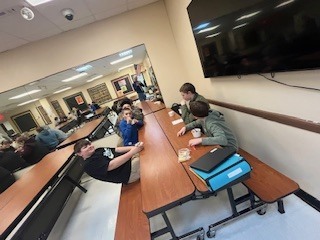 Students sitting at cafeteria tables enjoying ice cream during a school incentive celebration.