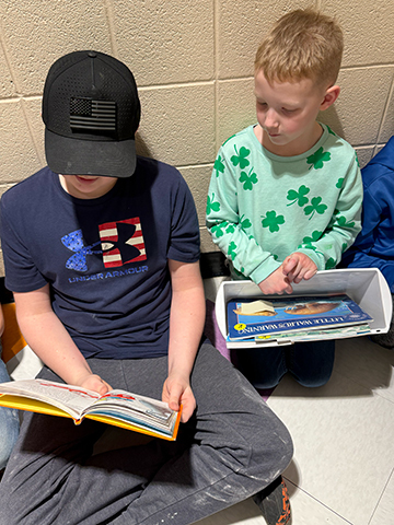 Otselic Valley students reading books together during Buddy Reading for Read Across America Week.