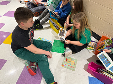 Otselic Valley students reading books together during Buddy Reading for Read Across America Week.
