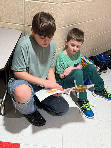 Otselic Valley students reading books together during Buddy Reading for Read Across America Week.