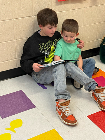 Otselic Valley students reading books together during Buddy Reading for Read Across America Week.